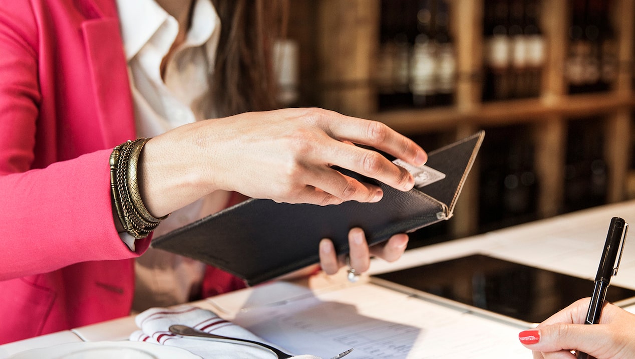 Woman paying restaurant bill using her GM Business Card