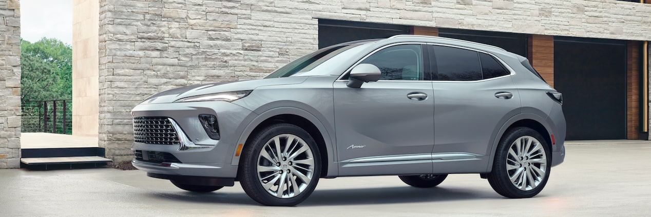 Side View of a Grey Buick Envision Avenir SUV Parked Next to a Building