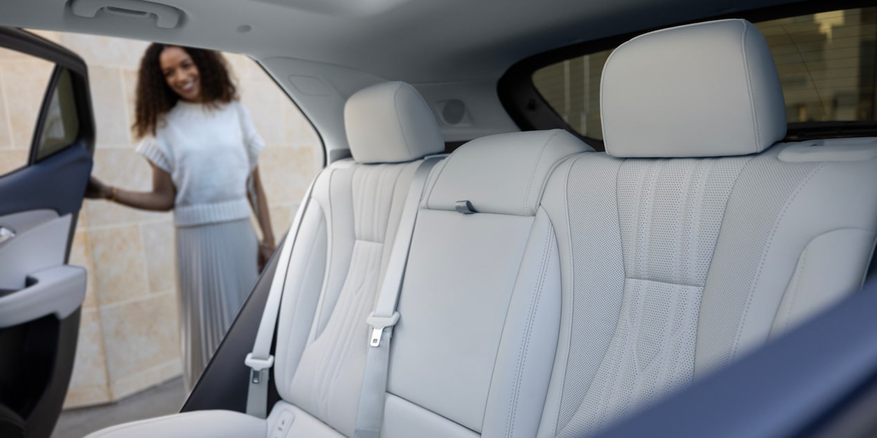 A Person Holding a Rear Door Open and Looking at the Rear Seating in a 2024 Buick Envision Avenir