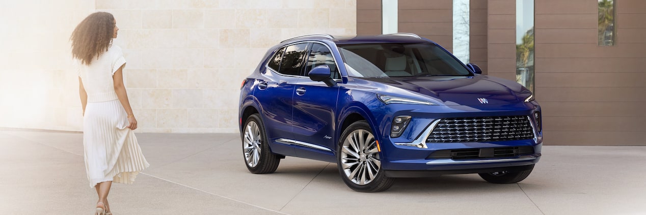 Wide Front Three-Quarters View of the 2024 Buick Envision Small SUV Parked In Front of a Building