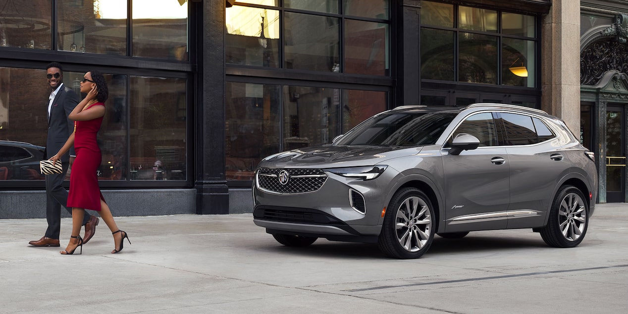 A Couple Leaving a Building Walking Towards their Stylish Buick Enclave Avenir