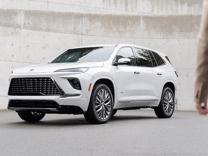 A Person Approaching a White 2025 Buick Enclave Surrounded by Walls