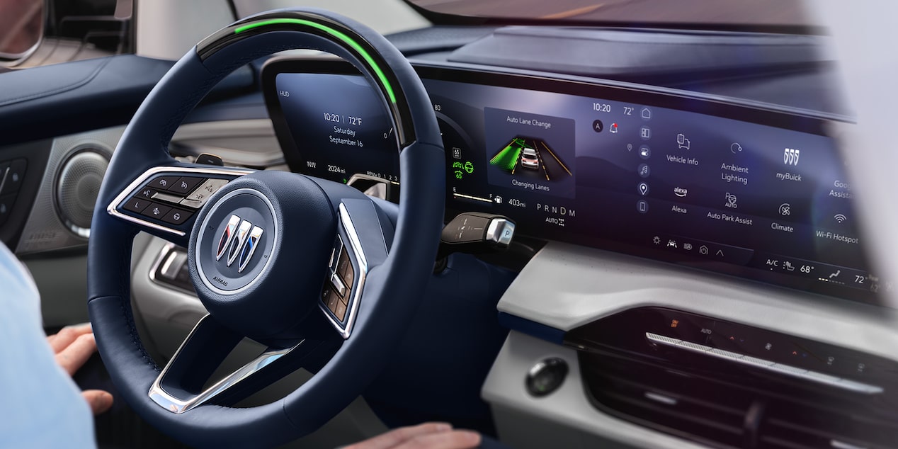 Close-up of the Steering Wheel and the Infotainment Screen with a Man Sitting in the Driver’s Seat of a 2025 Buick Enclave with SuperCuise in Use