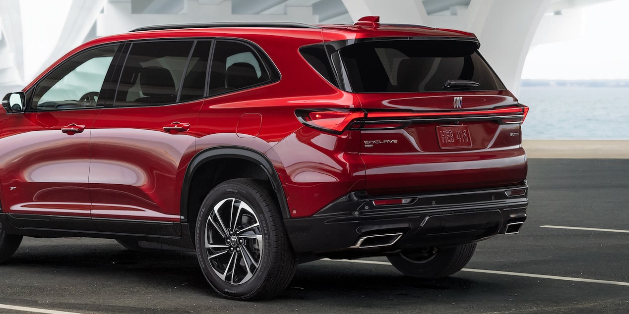 Three-Quarters Rear View of a Red 2025 Buick Enclave ST Under a Bridge