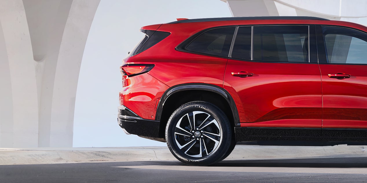 Side View the Red 2025 Buick Enclave ST Under a Bridge