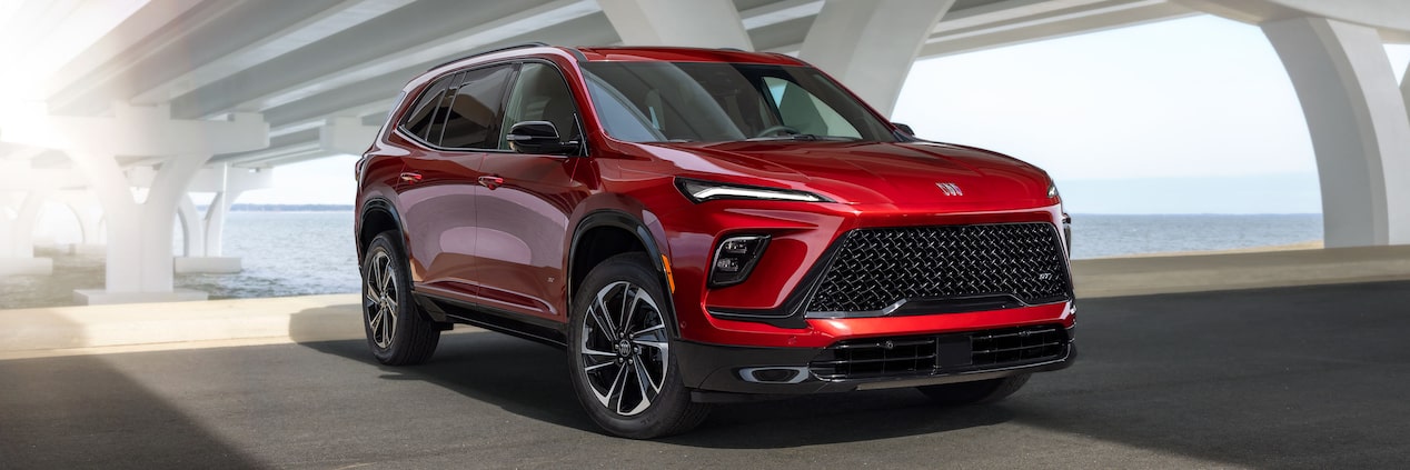 Three-Quarters View of a Red 2025 Buick Enclave ST Under a Bridge