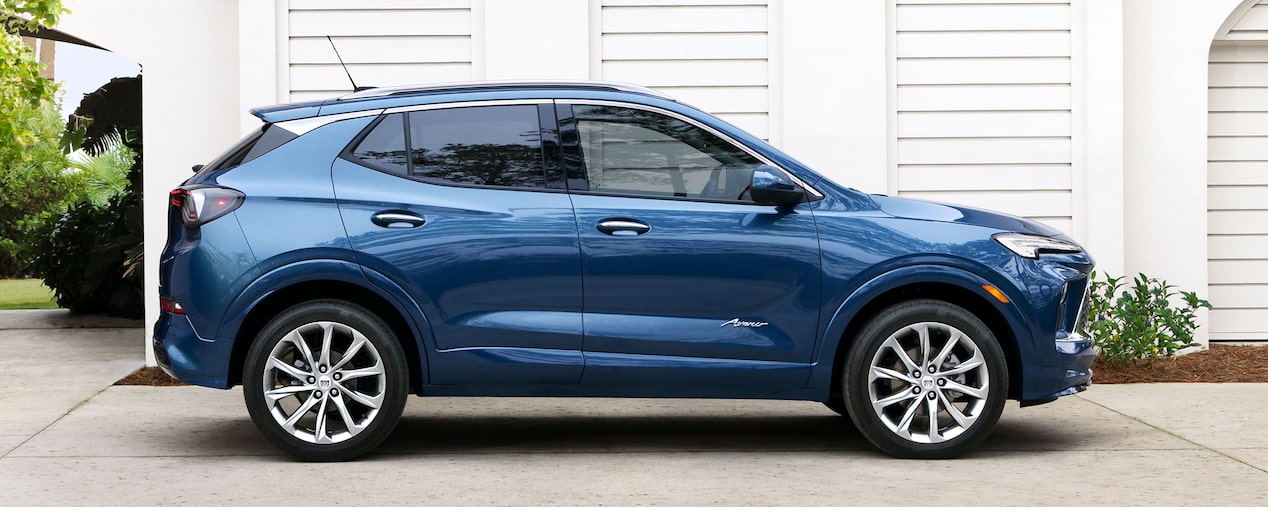 A Side Profile View of a Blue 2025 Buick Encore GX Parked Beside a Home