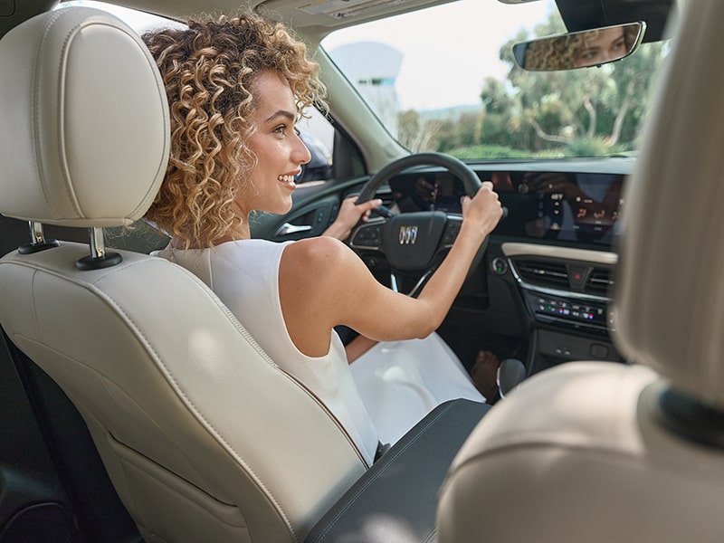 Back Seat View of Woman Smiling While Driving a 2025 Buick Encore GX