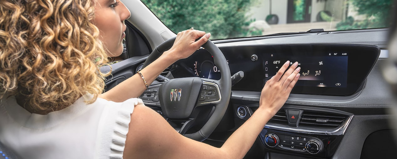 A Woman Selecting Air Flow Options on 2025 Encore GX Infotainment Screen