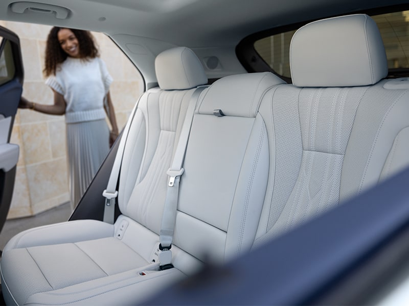 A Woman Looks into the Backseat of a 2025 Buick Envision Avenir Luxury SUV