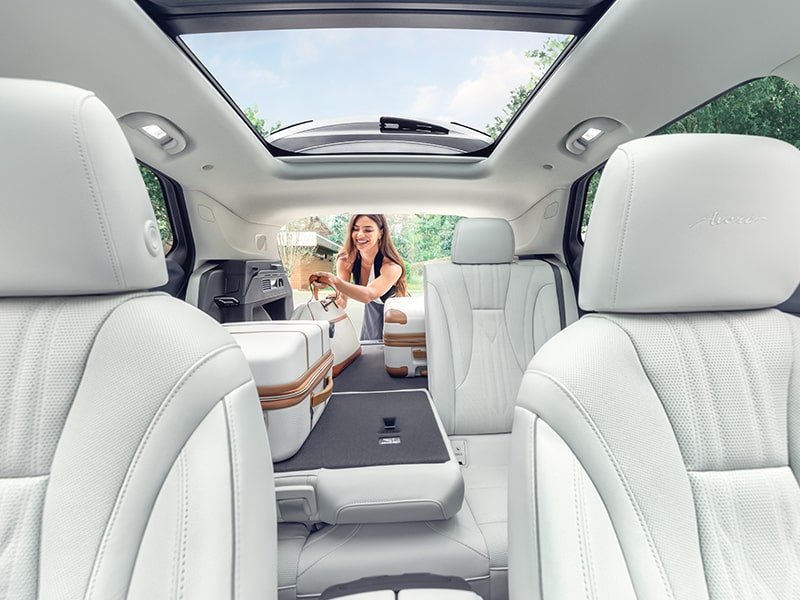 Interior View of a 2025 Buick Envision 5 Passenger SUV with a Person Loading Luggage Into the Trunk