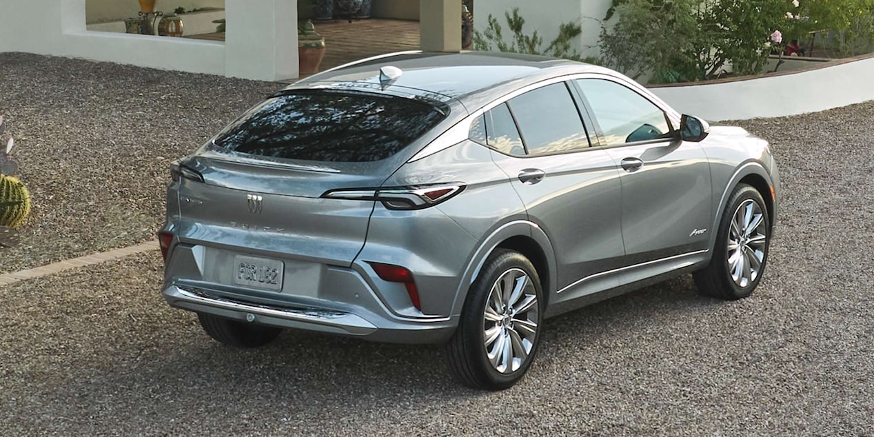 The Rear End View of a 2025 Buick Envista on a Gravel Driveway by a Beautiful Home