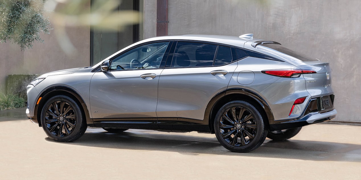 Driver Side View of the 2025 Buick Envista Avenir Luxury Coupe SUV Parked by a Concrete Building