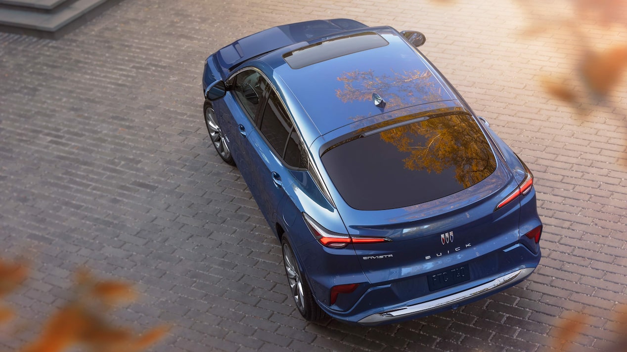 Overhead Rear View of a Blue 2025 Buick Envista Avenir Luxury Vehicle Parked with Crisp Orange Leaves in the Foreground