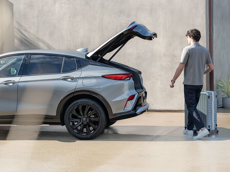 A Man wIth Luggage Walking to the 2025 Buick Envista and Utilizing the Power Liftgate Feature