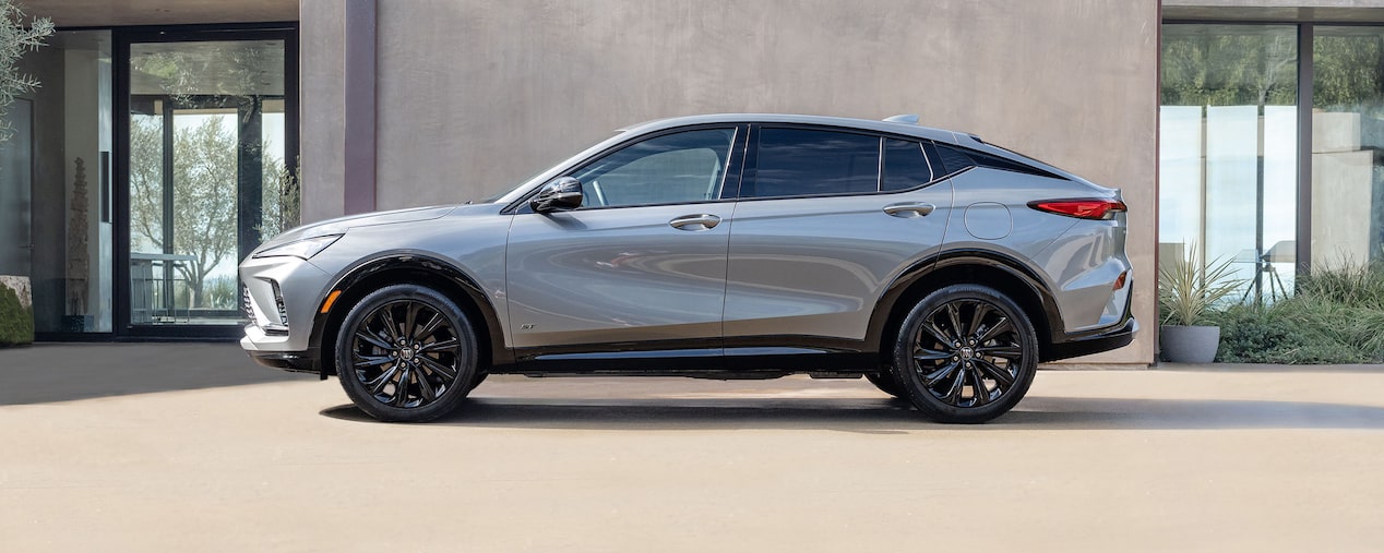 An Exterior Driver Side View of the 2025 Buick Envista ST Sport SUV Parked by an Industrial Concrete Building