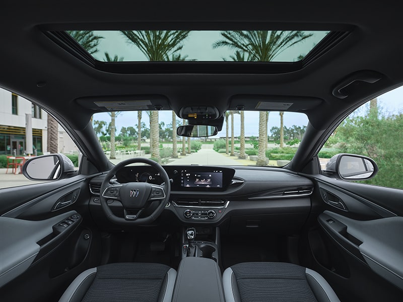 Full View of a Buick's Front Row Interior and Dashboard Outlooking Palm Trees