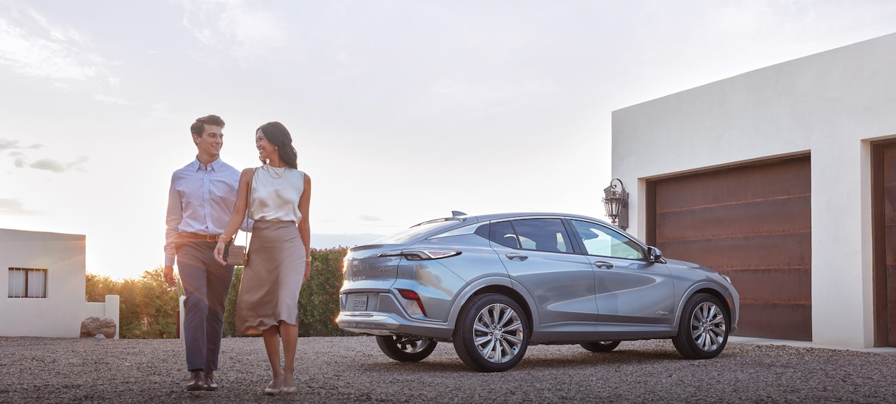 Couple walking next to their Buick vehicle