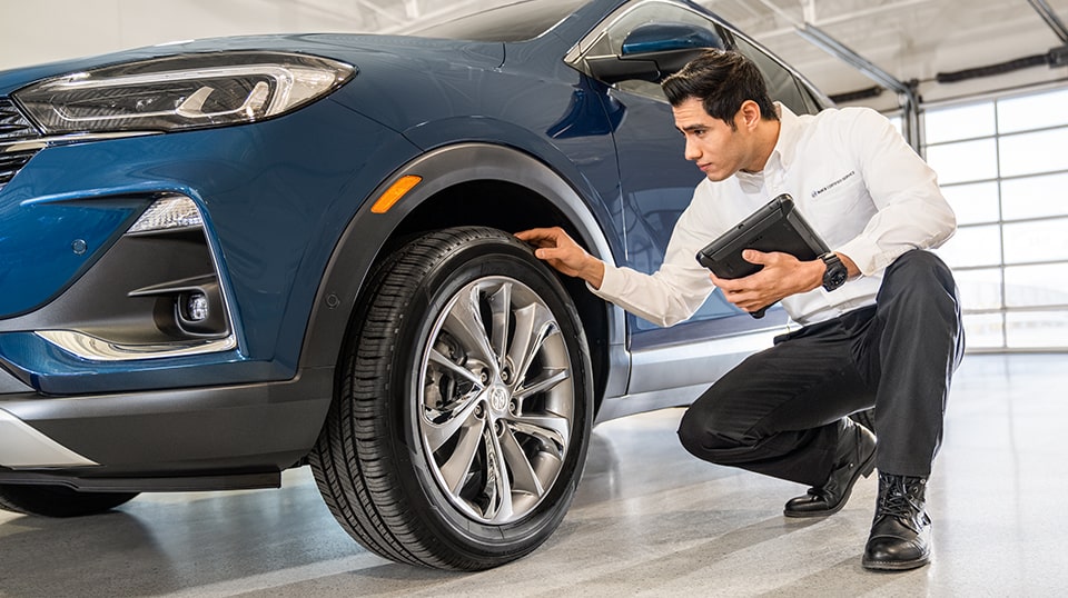 Buick Certified Service Representative Inspecting a Vehicle's Wheel