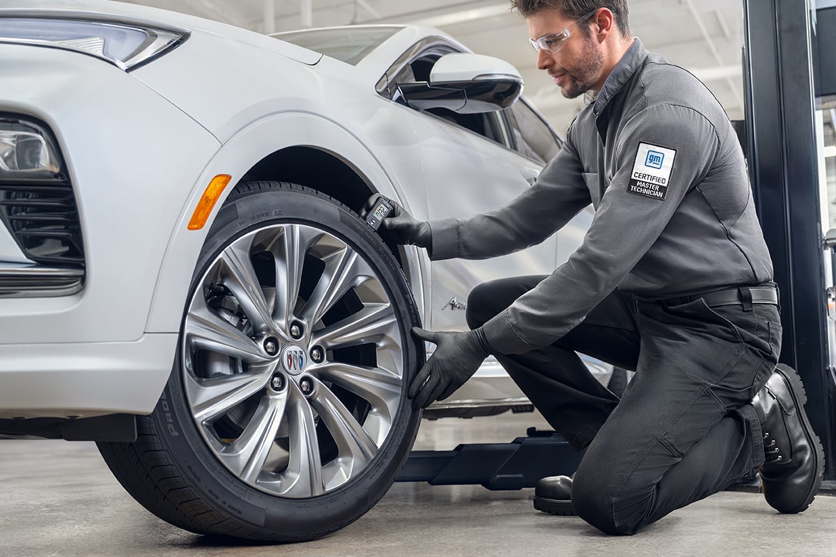 Buick Certified Service Representative Inspecting a Vehicle's Tire