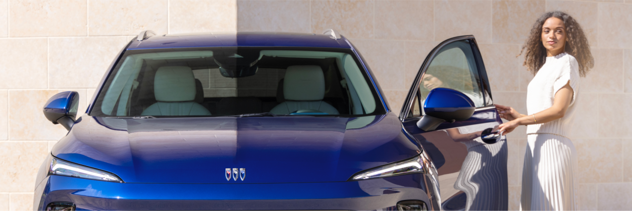 A Person Opening the Door of a Front Facing Blue Buick Envision Avenir